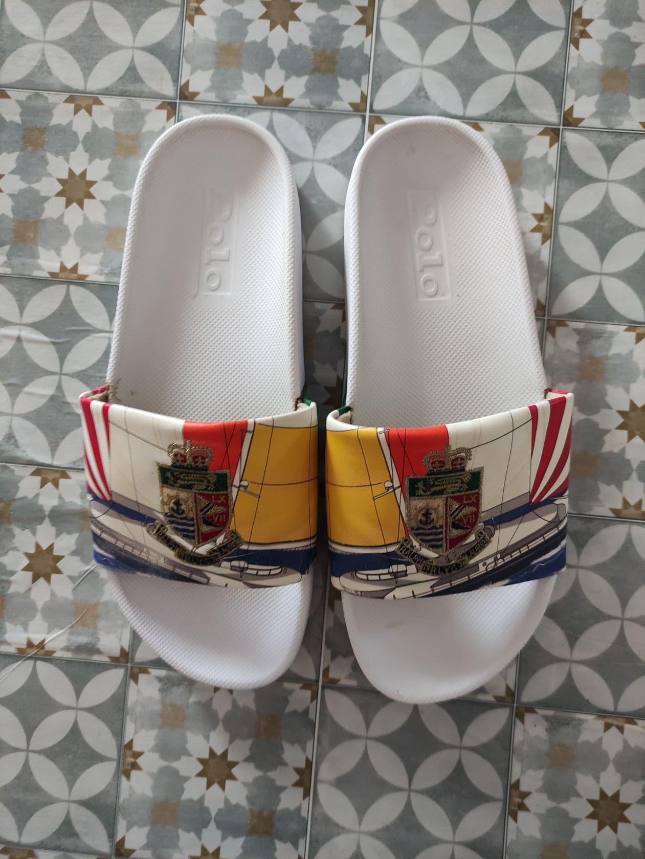claquettes de bain (slides) de la marque Polo Ralph Lauren, (le nom « Polo » est gravé en relief sur